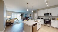 Located at 435 Duane St in Glen Ellyn, Illinois, this single-floor residence offers a thoughtfully designed open-concept layout that seamlessly connects the kitchen, dining, and living areas. The kitchen is a standout feature, showcasing white shaker cabinetry, a full suite of stainless steel appliances, light hardwood flooring, and a large central island with a built-in sink and dishwasher, highlighted by stylish pendant lighting overhead. The island provides casual seating, making it an ideal space for both meal preparation and entertaining. The living room is bright and welcoming, with large sliding glass doors that invite natural light and provide access to an outdoor area. Neutral tones and clean lines carry throughout the space, creating a cohesive and modern aesthetic. The two bedrooms feature plush carpeting, large windows with views of the surrounding neighborhood, and a calm, restful ambiance. Both bathrooms are finished with white quartz countertops, white cabinetry with modern hardware, large vanity mirrors, and neutral tile flooring — one featuring a double-sink vanity. The overall design balances contemporary finishes with functional living, making this Glen Ellyn residence a comfortable and well-appointed home.