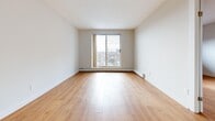 Located at 161 Nelson Street in Sarnia, Ontario, this 1-bedroom, 1-bathroom unit offers a practical and comfortable layout across a single floor. Warm hardwood-style flooring flows consistently throughout every room, creating a cohesive and inviting atmosphere.

The living room is a generously sized, open area bathed in natural light from a large sliding glass door that opens to a balcony with city views, making it a bright and airy centerpiece of the unit. A pendant light fixture adds a simple decorative touch overhead.

The kitchen features a galley-style design with crisp white cabinetry, subway tile backsplash, grey laminate countertops, and a full suite of white appliances including an electric range, built-in microwave, and dishwasher — offering efficient use of space.

The bedroom is a well-sized room equipped with two double-door closets providing ample storage, along with a baseboard heating unit. Neutral wall tones keep the room feeling calm and versatile.

The bathroom is clean and functional, featuring a tiled tub-surround, a white vanity with storage, a large mirror, and warm flooring that ties in with the rest of the unit. A hallway connects all rooms efficiently, completing this well-organized and move-in-ready space.