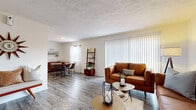 Located at 6401 Jamesville Dr in Tampa, Florida, this single-floor residence offers a thoughtfully designed layout that balances comfort and functionality. The open-concept living and dining area serves as the heart of the home, featuring wood-look flooring throughout, neutral walls, and a textured ceiling. Large windows with vertical blinds allow ample natural light to fill the living room, which provides generous space for seating. The adjacent dining area benefits from its own window with sheer curtains, creating a bright and inviting atmosphere for meals. The kitchen is outfitted with white cabinetry, light countertops, a double-basin sink, a dishwasher, and a range, offering practical storage and prep space. Both bedrooms are carpeted and well-proportioned, each featuring windows for natural light and closets for storage. A dedicated home office with carpeted floors, a window, and wall-mounted shelving provides a productive workspace. The full bathroom includes a tub-shower combination, a white vanity with storage, and wood-look flooring, rounding out this well-organized and comfortable residence in Tampa's 33617 zip code.