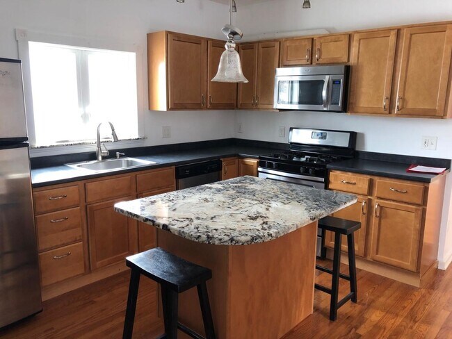 Kitchen with island and stainless steel appliances - 25 Savoy St