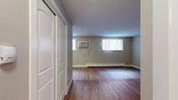 Located at 640 E Jefferson Ave in Englewood, Colorado, this efficiently designed single-floor unit offers a thoughtfully arranged living space ideal for straightforward, comfortable living. The open-plan layout seamlessly connects the living area to the kitchen, maximizing the use of available space. Warm wood-look laminate flooring runs continuously throughout, lending a clean and cohesive aesthetic to the interior.

The living area features neutral taupe-toned walls, bright vertical-blind windows that invite natural light, and a baseboard heating system running along the perimeter. A wall-mounted air conditioning unit ensures year-round comfort. The textured ceiling adds a subtle visual character consistent with the building's practical design.

The kitchen is positioned in the corner of the main space and is equipped with stainless steel appliances including a gas range and refrigerator, complemented by warm wood-toned cabinetry that provides ample storage.

The bathroom is a well-appointed full bath featuring wood-look tile flooring, a tub-shower combination with floor-to-ceiling tile surround accented by a decorative mosaic tile border, a rich cherry-toned vanity with an undermount sink, and chrome fixtures throughout. A closeted entryway area provides additional storage and a defined sense of entry to the space.