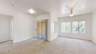 Located in Peoria, Arizona, this single-story 2-bedroom, 2-bathroom home offers a well-organized and functional layout. The living area is bright and open, featuring plush carpeting, a ceiling fan, a sliding glass door that leads to an outdoor patio, and large windows that invite abundant natural light and views of the surrounding greenery. The kitchen is equipped with light wood cabinetry, dark countertops, wood-look flooring, and white appliances including a range, over-the-range microwave, and refrigerator — providing a clean and practical cooking space. Both bedrooms are carpeted and feature windows with vertical blinds that frame outdoor views, creating comfortable and airy retreats. The primary bedroom is generously sized and includes a dedicated closet. Each of the two full bathrooms features wood-look flooring, a tub-shower combination, a white vanity with dark countertops, and a large mirror. A dedicated in-unit laundry room adds everyday convenience, complete with side-by-side washer and dryer units and shelving. Two hallways connect the rooms efficiently, and two closets provide ample storage throughout. The home's clean, neutral palette and consistent finishes create a cohesive and move-in-ready living environment.