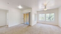 Located in Peoria, Arizona, this single-story 2-bedroom, 2-bathroom home offers a well-organized and functional layout. The living area is bright and open, featuring plush carpeting, a ceiling fan, a sliding glass door that leads to an outdoor patio, and large windows that invite abundant natural light and views of the surrounding greenery. The kitchen is equipped with light wood cabinetry, dark countertops, wood-look flooring, and white appliances including a range, over-the-range microwave, and refrigerator — providing a clean and practical cooking space. Both bedrooms are carpeted and feature windows with vertical blinds that frame outdoor views, creating comfortable and airy retreats. The primary bedroom is generously sized and includes a dedicated closet. Each of the two full bathrooms features wood-look flooring, a tub-shower combination, a white vanity with dark countertops, and a large mirror. A dedicated in-unit laundry room adds everyday convenience, complete with side-by-side washer and dryer units and shelving. Two hallways connect the rooms efficiently, and two closets provide ample storage throughout. The home's clean, neutral palette and consistent finishes create a cohesive and move-in-ready living environment.