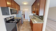 Located at 1492 Charlton St in West St. Paul, Minnesota, this single-floor residence offers a well-organized layout designed for comfortable everyday living. The galley-style kitchen is a functional highlight, showcasing rich warm-toned cabinetry, granite-look countertops, a mosaic tile backsplash, and a full suite of stainless steel appliances including an electric range, over-the-range microwave, refrigerator, and dishwasher. Tile flooring runs throughout the kitchen, which connects seamlessly to the rest of the unit. The living area is generously proportioned, featuring plush carpeting, a ceiling fan with integrated lighting, and a sliding glass door that opens to a private balcony, filling the space with natural light and outdoor views. Neutral, warm-toned walls create a clean and inviting atmosphere throughout. The bedroom offers ample space with plush carpet, a ceiling fan, and two closets providing abundant storage. An additional room also features dual closet access, offering flexible use as a second bedroom or office. The bathroom is well-appointed with a granite-topped vanity, rich wood cabinetry, white tile flooring, and a tub-shower combination. The unit's practical and thoughtfully designed layout makes it a comfortable and functional home in a convenient West St. Paul location.