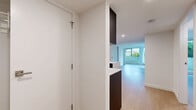 Located on Cardero Street in Vancouver's desirable West End, this modern 2-bedroom, 2-bathroom residence offers a thoughtfully designed single-level layout with clean contemporary finishes. The open-concept living, dining, and kitchen area forms the heart of the home, bathed in natural light through large floor-to-ceiling windows and sliding glass doors that open to an outdoor area with lush greenery views. Light hardwood flooring flows throughout the main living spaces, complementing the crisp white walls and creating a bright, airy ambiance. The kitchen features dark cabinetry contrasted against white marble-style countertops, adding a sophisticated touch to the space. Both bedrooms are generously proportioned, with large windows that invite natural light and offer green outlooks. The spacious primary bedroom includes access to a walk-in closet and an adjoining bathroom. Both bathrooms are finished in a consistent modern palette of white subway tiles, dark countertops, vessel sinks with mirrored medicine cabinets, soaker tubs, and grey porcelain tile flooring. An in-unit stacked washer and dryer adds everyday convenience. The overall aesthetic is clean, minimal, and move-in ready.