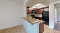 Located at 2000 Gandy Blvd N in Saint Petersburg, FL, this one-bedroom, one-bathroom unit offers a efficiently designed single-floor layout. Tile flooring runs consistently throughout the space, lending a clean, cohesive look to every room.

The kitchen is a standout feature, showcasing rich dark wood cabinetry, granite countertops, and a mosaic tile backsplash. Black appliances — including a gas range, microwave, and refrigerator — complement the warm tones of the cabinetry. A peninsula with matching granite extends into the living area, providing additional prep space and a natural division between the kitchen and main living area.

The living area is bright and open, benefiting from a window that brings in natural light and offers views of the surrounding greenery. A textured ceiling and neutral wall tones create a calm, understated ambiance throughout.

The bedroom is a comfortable, well-proportioned room with its own window and direct access to the rest of the unit. A dedicated closet provides practical storage.

The bathroom features the same rich dark cabinetry and granite countertop as the kitchen, paired with a large mirror, a soaking tub with shower, and tile flooring — offering a cohesive and polished finish. The unit includes a dedicated closet for added storage convenience.