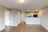 Located at 3500 S Grand Slam Ave in Sioux Falls, South Dakota, this 2-bedroom, 1-bathroom residence offers a thoughtfully designed single-floor layout with a clean, modern aesthetic throughout. The open-concept living and kitchen area serves as the heart of the home, where light-toned luxury vinyl plank flooring flows seamlessly underfoot. The kitchen features white cabinetry, dark countertops, a peninsula with a breakfast bar overhang, a built-in dishwasher, refrigerator, and microwave — all finished in black — providing both style and functionality. Recessed lighting illuminates the space, while a sliding glass door off the living area adds natural light and outdoor access. The primary bedroom is a generously sized retreat with durable wood-look flooring, neutral warm-toned walls, and direct access to a closet. The second bedroom is carpeted, offering a softer, cozier feel. The full bathroom is well-appointed with white cabinetry, a stone-look countertop, a large mirror, and a full tub-shower combination. A dedicated laundry area houses a full-size washer and dryer with overhead shelving. The space combines practical amenities with a neutral, move-in-ready aesthetic throughout.