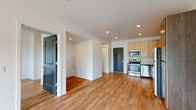 Located at 8255 West Limelight Street in Boise, Idaho, this single-floor unit offers a thoughtfully designed open-concept layout with a bright, contemporary aesthetic throughout. Light wood-style flooring flows seamlessly across all living areas, complementing the clean white walls and recessed lighting that keep the space feeling airy and well-lit.

The kitchen is a standout feature, equipped with a full suite of stainless steel appliances including a range, microwave, dishwasher, and refrigerator. Light maple upper cabinets are paired with warm wood-toned lower cabinets, and a marble-style tile backsplash adds a polished finishing touch. The kitchen opens directly into the main living area, creating a connected and functional layout ideal for everyday living.

The living area is generously proportioned, bathed in natural light from sliding glass doors that lead to a private balcony with an outdoor railing, offering views of the surrounding neighborhood. A textured ceiling with recessed lighting adds subtle character to the space.

The bedroom is comfortably sized with a ceiling fan, a large window for natural light, and the same warm wood flooring found throughout. The bathroom features a full tub-shower combination with matte black fixtures, a wood-toned vanity, and clean white finishes. Hallways connect the rooms efficiently, with bold slate-blue interior doors adding a modern design accent throughout.