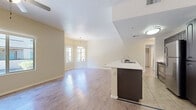 Located at 9971 E Speedway Blvd in Tucson, Arizona, this single-floor residence offers a well-designed open-concept layout that seamlessly connects the main living areas. The living and dining spaces are finished with warm hardwood-style flooring that reflects natural light streaming in through generously sized windows. A pendant light fixture anchors the dining area, adding a refined touch to the open layout.

The kitchen is a functional centerpiece, featuring a peninsula with a white countertop and an integrated sink, contrasted by dark cabinetry. Stainless steel appliances, including a refrigerator and range, provide a modern finish, while tile flooring distinguishes the kitchen from the adjoining living areas. A ceiling fan in the living area enhances comfort throughout.

Bedroom spaces are accounted for with practical closet storage, including a rod and shelving for organized living. Sliding glass doors in one room open to an outdoor patio, offering views of the surrounding exterior and filling the space with natural light. Each bathroom is finished with tile flooring and includes a full tub-shower combination with clean white surrounds and chrome fixtures. The overall palette of soft warm neutrals throughout creates a bright, cohesive, and inviting atmosphere.
