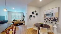 This single-floor residence at 547–553 Berkley Pkwy in Kansas City, MO offers a thoughtfully designed open-concept layout with modern finishes throughout. Light wood flooring runs through the main living areas, complementing the neutral color palette and creating a cohesive, contemporary aesthetic.

The kitchen is a standout feature, boasting tall white cabinetry, dark quartz countertops, a subway tile backsplash, stainless steel appliances, and a large island with a deep undermount sink. Pendant lighting adds a refined touch, and an adjacent laundry area provides added convenience. The open dining area connects seamlessly to the living room, which features large windows with ample natural light and generous ceiling height.

Multiple bedrooms offer comfortable retreats, each with carpeted flooring, ceiling fans, and windows that invite natural light. The bathrooms are finished with light wood-toned cabinetry, dark quartz countertops, wide vanity mirrors, and wood-look flooring. One bathroom includes a full tub and shower combination.

Decorative wall-mounted planters in the dining area and contemporary artwork throughout add character, while the overall design prioritizes clean lines and functional living across every room.