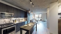 Located in Chicago's vibrant West Loop neighborhood, this single-floor residence at 172 N Ada St blends industrial aesthetics with modern design. The space is immediately defined by its signature exposed concrete ceilings, which extend throughout and lend an authentic urban character to every room.

The open-concept kitchen and living area form the heart of the unit. The kitchen is outfitted with floor-to-ceiling dark cabinetry, stainless steel appliances including a gas range and built-in microwave, a textured tile backsplash, and a substantial island with dark granite countertops — ideal for both cooking and casual dining. Warm Edison-style pendant lighting adds an inviting atmosphere. Light-toned hardwood flooring flows seamlessly into the living area, which benefits from expansive floor-to-ceiling windows that flood the space with natural light and offer open views of the surrounding neighborhood. A private balcony is accessible directly from the living area, extending the usable space outdoors.

The bedroom continues the floor-to-ceiling window motif, with direct balcony access and generous natural light. The bathroom features large-format light tile flooring, a wide vanity with a white countertop, an illuminated mirror, and matte black fixtures, conveying a clean, contemporary feel. The overall layout is efficient and well-proportioned, reflecting thoughtful modern urban design.