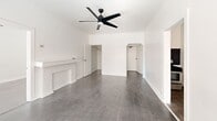 Located at 687 Shatto Place in the heart of Los Angeles' Koreatown, this three-bedroom, one-bathroom unit offers a clean, minimalist aesthetic throughout its single-floor layout. The interior is finished with durable dark hardwood-style flooring that runs through the main living areas and bedrooms, complemented by crisp white walls and classic crown molding that add a timeless character to each room.

The spacious primary bedroom is notably generous in size, featuring a ceiling fan, ample natural light, and direct access to a dedicated walk-in closet equipped with built-in shelving and hanging rods. The two additional bedrooms are well-proportioned, each fitted with ceiling fans and windows dressed with horizontal blinds that allow natural light to filter in. One bedroom also features a decorative white fireplace mantel, adding a charming architectural detail.

The kitchen stands out with its striking contrast of white shaker-style cabinetry, dark granite countertops, and a bold black subway tile backsplash, paired with a stainless steel refrigerator and sink. The bathroom offers a full tub-and-shower combination with white tiled surround and a vanity with sink. A connecting hallway ties the layout together efficiently, completing a practical and cohesive living space.
