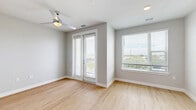 Located at 2210 N Orange Blossom Trail in Orlando, FL, this thoughtfully designed one-bedroom, one-bathroom unit offers a clean, modern aesthetic across a single floor. The open-concept living, dining, and kitchen area is anchored by light wood-look flooring and neutral gray walls, creating a bright and cohesive atmosphere. A ceiling fan and large windows with blinds allow natural light to fill the space, while a glass-panel balcony door opens to an outdoor balcony with pleasant outdoor views. The kitchen is well-appointed with white shaker-style cabinetry, quartz countertops, a white subway tile backsplash, stainless steel appliances including a dishwasher, microwave, and electric range, and a single-basin undermount sink. The bedroom features plush carpeting, a ceiling fan, and ample space, complemented by a generous walk-in closet with built-in shelving and hanging rods — plus two additional closets for storage. The bathroom is finished with large-format tile flooring, a vanity with quartz countertop, a framed mirror, and a tub-shower combination with white tile surround. An in-unit laundry area adds everyday convenience. The overall design is clean, contemporary, and move-in ready.