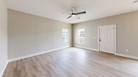 This contemporary 1040 square foot residence in Biloxi, MS offers a well-designed living space with 3 bedrooms and 2 bathrooms. The home's single-story layout promotes easy accessibility and flow between rooms. Light wood-look flooring runs throughout, complementing the neutral wall tones and creating a cohesive, modern aesthetic.

The primary bedroom, measuring 180 square feet, provides a spacious retreat. Large windows in the bedrooms and living areas flood the interior with natural light, enhancing the sense of openness. Modern ceiling fans ensure comfort and air circulation.

The kitchen showcases a galley-style design with sleek white cabinetry, contrasting black hardware, and stainless steel appliances. Quartz countertops add a touch of elegance, while the open concept allows for seamless interaction with the living and dining areas.

Both bathrooms feature contemporary fixtures, including vanities with ample storage and modern shower/tub combinations. The main bathroom boasts a stylish backlit mirror and a walk-in shower with marble-look tiling.

Additional amenities include a utility room and closet space for added convenience and storage. The property's layout, as seen in the 3D floor plan, demonstrates an efficient use of space, making it an ideal choice for both comfortable family living and potential investment opportunities.
