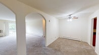 Located at 519 E Circle Hill Dr in Arlington Heights, IL, this single-floor unit offers a practical and well-organized layout suited for comfortable everyday living. The living area is generously proportioned, featuring neutral-toned carpet and a ceiling fan with light fixture overhead. A distinctive arched doorway connects the living space to an adjoining room, adding a subtle architectural detail to the otherwise clean-lined interior. Baseboard heating is present throughout, and a wall-mounted air conditioning unit ensures year-round climate control.

A spacious room features a sliding glass door that opens to a private balcony, bringing in natural light and outdoor views of the surrounding greenery. Additional carpeted rooms provide versatile spaces, each with access to hallways and closets as shown in the floor plan.

The kitchen is a notable highlight, featuring rich cherry-toned cabinetry, dark granite-style countertops, stainless steel appliances including a refrigerator, range, microwave, and dishwasher, and tile-style flooring. A ceiling fan overhead adds ventilation and light to the space.

Two bathrooms serve the unit, each equipped with a tub-shower combination. One bathroom includes a vanity with dark countertops and wood cabinetry, while both maintain a clean, functional aesthetic with tile flooring and chrome fixtures.
