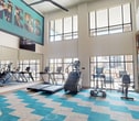 This contemporary fitness center, located at 3103–3209 Walton Rd in Corinth, TX, is a spacious 2,130 square foot facility spread across two floors. The ground floor, measuring 650 square feet, seamlessly connects to the larger 1,480 square foot upper level. The space boasts a striking blue and gray geometric carpet pattern, creating a dynamic and energizing atmosphere.

The facility is equipped with a comprehensive array of modern exercise equipment, including treadmills, ellipticals, weight machines, and free weights. Large windows line the walls, allowing ample natural light to flood the space and providing views of the surrounding area. The high ceilings, adorned with modern ceiling fans, contribute to the open and airy ambiance.

A prominent feature is the motivational wall art, displaying an inspiring message that encourages members to push their limits. The center's layout is thoughtfully designed, with dedicated areas for cardio, strength training, and functional fitness. Mirrors line some walls, allowing users to monitor their form during workouts.

The facility's modern aesthetic is further enhanced by recessed lighting, sleek equipment finishes, and a clean, minimalist design approach. This well-appointed fitness center offers a premium exercise experience in a stylish, contemporary setting.