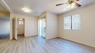 This single-floor residence offers a clean, contemporary living environment with light wood-style flooring that extends consistently throughout the space, creating a cohesive and airy feel. The living area is bright and open, featuring a ceiling fan with integrated lighting, vertical blinds, and a window that brings in natural light. A sliding glass door provides access to an outdoor area, adding to the sense of openness.

The kitchen is well-equipped with white cabinetry, light stone-finish countertops, and a full suite of stainless steel appliances, including a range, over-the-range microwave, refrigerator, and dishwasher. The layout allows for efficient use of space while maintaining a clean, modern aesthetic.

The bedrooms are generously sized, each featuring ceiling fans and walk-in closets with built-in shelving, offering ample storage. Neutral walls and consistent flooring throughout contribute to a calm and versatile atmosphere.

The bathroom is finished with a clean white tub-shower combination and light wood-style flooring. A dedicated in-unit laundry room with a full-size washer and dryer, overhead shelving, and a window rounds out the practical amenities of this thoughtfully designed space.