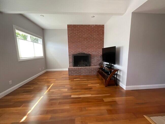 Sala de estar con grandes ventanales y chimenea. - 2452 Harding Ave