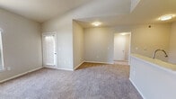 Located on 82nd Street in Lubbock, Texas, this well-designed one-bedroom, one-bathroom home offers a comfortable and functional layout across a single floor. The living room is a bright, welcoming space featuring tall ceilings, soft neutral wall tones, and plush carpeting underfoot. Distinctive arched windows allow natural light to pour in, creating an airy and open atmosphere, while a glass-paneled entry door adds to the room's charm.

The kitchen is efficiently designed in a galley style, featuring crisp white cabinetry with brushed nickel hardware, light-toned countertops, and wood-look vinyl flooring. Black appliances, including a refrigerator, range, and over-the-range microwave, provide a clean contrast to the white cabinetry, while additional storage and a washer/dryer connection round out the space.

The bedroom is a comfortable retreat, also finished with plush carpeting and neutral walls, offering a tranquil environment. A dedicated closet provides practical storage. The full bathroom is clean and well-appointed, featuring a tiled shower-tub combo, a white vanity with ample cabinet storage, and wood-look vinyl flooring that ties the space together cohesively. The overall aesthetic of this home is clean, neutral, and move-in ready.