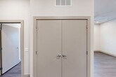 This well-designed two-bedroom, two-bathroom unit at 7520 Avenue C in Houston, Texas offers a clean, modern aesthetic across a thoughtfully laid-out single floor. The kitchen is outfitted with light wood-toned cabinetry, white subway tile backsplash, granite-look countertops, and stainless steel appliances including a full-size refrigerator and dishwasher — providing both style and functionality. Wood-look plank flooring runs throughout the entire unit, lending a cohesive and contemporary feel to every room. Both bedrooms are bright and well-proportioned, featuring large windows with blinds that invite natural light and offer views of the surrounding neighborhood. One bedroom is equipped with a ceiling fan for added comfort. The primary bedroom is complemented by a dedicated walk-in closet with multiple shelving rods and a built-in bench shelf, offering generous storage. The two bathrooms are finished with granite-topped vanities and wood-toned cabinetry; one includes a tub-shower combination with white tile surround, while the other features a tiled shower. The overall palette — neutral walls, warm flooring, and clean white trim — creates a bright and inviting atmosphere throughout this move-in-ready Houston residence.