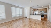 This contemporary 700 square foot apartment offers a thoughtfully designed living space. The open-concept layout seamlessly integrates the living room, dining area, and kitchen, creating a spacious feel. The kitchen boasts modern light wood cabinetry, stainless steel appliances, and a stylish island with a granite countertop, perfect for casual dining or meal preparation.

The bedroom, measuring 120 square feet, features plush carpeting and large windows that flood the space with natural light. Window treatments provide privacy and light control. A generously sized closet with wire shelving offers ample storage space.

The bathroom showcases a sleek design with a granite-topped vanity, modern fixtures, and a combination tub-shower. Throughout the apartment, you'll find durable wood-look flooring, recessed lighting, and neutral-toned walls, creating a bright and inviting atmosphere.

Large windows in the living area and bedroom not only provide abundant natural light but also offer potential views of the surroundings. The apartment's clean lines, modern fixtures, and thoughtful layout make it an ideal space for comfortable, contemporary living.