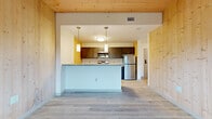 Located at 340 Dixwell Ave in New Haven, CT, this 2-bedroom, 2-bathroom residence showcases a thoughtful architectural design centered around the warmth of natural wood. Tongue-and-groove wood paneling lines the walls and ceilings throughout, creating a cohesive, nature-inspired aesthetic that sets this home apart.

The open-concept living, dining, and kitchen area forms the heart of the unit. The kitchen is well-appointed with dark cabinetry, granite-style countertops, stainless steel appliances — including a refrigerator, range, microwave, and dishwasher — and pendant lighting. A peninsula counter provides additional workspace and separates the kitchen from the living and dining areas, which are finished with light luxury vinyl plank flooring.

Both bedrooms continue the signature wood-paneled design on walls and ceilings, offering a warm and inviting atmosphere. Each bedroom features windows overlooking lush outdoor greenery, filling the rooms with natural light. Four closets throughout the unit provide ample storage. A connecting hallway leads to the two bathrooms, which are finished with clean white walls, light flooring, and dark vanity cabinetry. The unit spans a single floor, offering an efficient and accessible layout.
