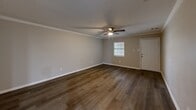 Located at 11300 Mesa Dr in Little Rock, Arkansas, this single-story 2-bedroom, 1-bathroom home offers a practical and updated living environment with thoughtfully selected finishes throughout. The open living room serves as the heart of the home, featuring rich dark hardwood-style flooring, crown molding, a ceiling fan, and a window that lets in natural light — creating a warm, inviting atmosphere. The kitchen is efficiently designed with a galley-style layout, showcasing crisp white cabinetry, light granite-style countertops, a stainless steel sink, and black appliances including a refrigerator, electric range, and dishwasher, all complemented by light vinyl plank flooring. Both bedrooms are comfortably sized, each equipped with ceiling fans and hardwood-style flooring. The primary bedroom offers generous space, while the second bedroom includes a closet and natural light from a window. The bathroom is a standout feature, finished with large-format marble-look tile surrounding a clean white soaking tub and shower combination, lending an elegant touch. Neutral wall tones and consistent flooring tie the home together with a cohesive, move-in-ready aesthetic.