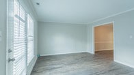 Located at 2100 Criston Dr in Newport News, Virginia, this two-story home offers a well-organized layout designed for comfortable everyday living. The main level features durable hardwood-style flooring throughout, beginning with a welcoming hallway that connects the principal living areas. The living room is bright and open, with neutral gray walls, crown molding, and a glass-paneled door that allows natural light to pour in and provides access to the outdoors. Adjacent to the living room, a separate dining area showcases elegant chair rail molding and crown molding details, flowing seamlessly into the kitchen. The kitchen is well-appointed with white shaker-style cabinetry, dark countertops, a full suite of black appliances including a range, dishwasher, and refrigerator, and a window above the sink that brings in additional natural light. Upstairs, the home transitions to plush carpeted bedrooms. The generously sized primary bedroom features dual closets and a bright window, providing ample storage and comfort. Additional bedrooms offer soft carpeting and neutral tones. The bathroom includes a tiled tub-and-shower combination. A connecting hallway with hardwood-style flooring ties the upper level together efficiently, completing this practical and well-maintained home.