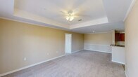Located on Kaliste Saloom Road in Lafayette, Louisiana, this well-appointed 2-bedroom, 2-bathroom residence offers a comfortable and functional single-floor layout. The combined kitchen and living area serves as the heart of the home, with the kitchen featuring rich wood cabinetry, dark granite-style countertops, stainless steel appliances including a range and microwave, and light hardwood-style flooring. The living room is highlighted by a tray ceiling with crown molding, a ceiling fan, plush carpeting, and French doors that invite natural light and outdoor views.

Both bedrooms are carpeted and feature ceiling fans with light fixtures. The generously sized primary bedroom includes a walk-in closet and direct access to its en-suite bathroom. The second bedroom is equally bright, with a window offering views of surrounding greenery. Each bathroom is thoughtfully designed — one features a wide vanity with a light-colored stone countertop and a soaking tub, while the other offers light hardwood-style flooring and a clean, efficient layout.

A dedicated laundry room with a Whirlpool washer and built-in shelving adds everyday convenience. Warm beige tones, white trim, and panel doors carry throughout, creating a cohesive and inviting atmosphere across the entire residence.