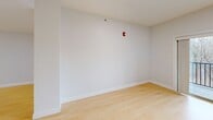 This 870 square foot apartment in South Burlington, VT offers a practical and contemporary living space. The single-floor layout comprises two bedrooms, one bathroom, and an open-concept kitchen and living area. The primary bedroom, measuring 140 square feet, provides a comfortable retreat.

Throughout the apartment, light wood flooring adds warmth and continuity. Large windows in the bedrooms and living area flood the space with natural light, while white plantation shutters offer privacy control. The crisp white walls create a clean, modern aesthetic and amplify the sense of spaciousness.

The kitchen features white cabinetry, contrasting black appliances, and a practical breakfast bar. The bathroom is outfitted with a white vanity, large mirror, and a shower/tub combination. Recessed lighting and modern fixtures contribute to the overall contemporary feel.

Safety features include fire alarms visible in several rooms. The apartment's efficient design maximizes the use of space, making it an ideal choice for those seeking a low-maintenance, modern living environment in a convenient South Burlington location.