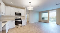 Located in San Diego's North Park neighborhood, this 2-bedroom, 1-bathroom residence offers a well-designed, single-floor layout with a clean, modern aesthetic throughout. Light wood-tone flooring flows seamlessly across the entire space, creating a warm and cohesive feel.

The open-concept kitchen and living area serves as the heart of the home. The kitchen is outfitted with white shaker cabinetry, stainless steel appliances including a French door refrigerator, electric range, built-in microwave, and dishwasher, along with a pendant drum light fixture that adds a contemporary touch. The adjacent living area benefits from a large window that draws in natural light and opens to views of the surrounding neighborhood.

A hallway connects the main living area to the two bedrooms and shared bathroom. The spacious primary bedroom features a generous closet and an oversized window with outdoor views. The second bedroom also enjoys natural light through a well-positioned window. Both rooms feature neutral-toned walls that complement the light flooring.

The bathroom is finished in white, featuring a combined tub and shower, a white vanity with storage, and a large mirror. A private balcony rounds out the layout, offering additional outdoor space. The unit also includes a dedicated closet for added storage.
