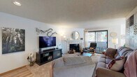 Located at 1105 Fircrest Dr in Fircrest, Washington, this two-bedroom, two-bathroom single-floor home offers a thoughtfully arranged layout that maximizes every square foot. The inviting living room serves as the heart of the home, centered around a tile-surround fireplace with a white mantle and flanked by a large sliding glass door that fills the space with natural light and provides outdoor access. Soft carpeting and a textured ceiling carry throughout the living areas, lending a warm, comfortable feel.

The galley-style kitchen is efficiently designed with ample cabinetry, light green laminate countertops, a double-basin sink, and a window that brings in natural light. It connects seamlessly to a dedicated dining area, which also benefits from generous window coverage and light-filtering curtains.

The primary bedroom is a comfortable retreat, featuring plush carpet and warm neutral tones. The second bedroom, equally well-lit, includes a large window with sheer curtains and built-in baseboard heating. Both bathrooms are clean and functional, with one featuring a wide vanity, large mirror, and a shower-tub combination with wood-toned cabinetry accents. A connecting hallway ties all rooms together for easy flow throughout this well-maintained Fircrest home.