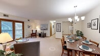 Located at 14663 Chicago Ave in Burnsville, Minnesota, this single-floor home offers a practical and comfortable layout across a well-utilized footprint. The living room is bright and welcoming, featuring soft carpeting, neutral walls, and sliding glass doors that open to an outdoor balcony, filling the space with natural light. The adjacent dining area accommodates generous seating and is anchored by a stylish multi-light chandelier, with a gallery of framed artwork adorning the walls above the dining table. The galley-style kitchen is efficiently designed with ample cabinetry featuring wood-trimmed accents, tile flooring, and a full suite of appliances including a range, refrigerator, dishwasher, and built-in microwave. The dedicated office provides a versatile space with carpeted flooring, a large closet, and a window overlooking the outdoors. Both bathrooms are finished with wide vanities, louvered wood cabinetry, and large mirrors. The in-unit laundry room includes a full washer and dryer with additional shelving for storage. Throughout the home, warm wood trim details, textured ceilings, and carpeted living areas contribute to a cohesive and comfortable residential ambiance.