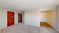 Located at 1603 Patricia Drive in Yeadon, PA, this single-floor unit offers three bedrooms, one full bathroom, a kitchen, and two hallways within a well-organized layout. The generously sized primary bedroom features soft carpeting, neutral gray walls, a window with natural light, a wall-mounted air conditioning unit, and baseboard heating. Additional bedrooms are similarly finished with plush carpet, neutral tones, baseboard heaters, and windows that bring in outdoor views — one includes a closet for convenient storage. The kitchen is equipped with white cabinetry, granite-look countertops, a white electric range, a full-size refrigerator, and a stainless steel sink, all set atop warm wood-tone flooring. The bathroom features tile-style flooring, a white vanity, a toilet, and clean gray walls, accessed through a classic wood-paneled door. Throughout the unit, warm wood-tone and rich red-stained interior doors add character against the neutral color palette. Hallways connect the rooms efficiently, contributing to a functional and cohesive floor plan. Baseboard heating is present throughout, ensuring consistent comfort. The overall ambiance is clean, understated, and move-in ready.