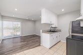 Located at 536 Linden Ave in Long Beach, CA, this one-bedroom, one-bathroom unit offers a well-organized single-floor layout designed to maximize functionality. The interior is finished with soft gray walls and clean white trim throughout, creating a cohesive and modern aesthetic.

The galley-style kitchen is a standout feature, equipped with white cabinetry, granite countertops, a double basin sink with a matte black faucet, and stainless steel appliances including a refrigerator and electric range. Light tile flooring runs through the kitchen, providing a clean contrast to the wood-look flooring found in the living and bedroom areas.

The living room benefits from recessed lighting and a ceiling fan, while a sliding glass door with horizontal blinds invites natural light and provides outdoor access. The bedroom is a comfortable size, also featuring wood-look flooring, a ceiling fan with recessed lighting, and a window with blinds that allows for natural light.

The bathroom is clean and functional, outfitted with a full tub-shower combination, a white vanity with an oil-rubbed bronze faucet, and a mirror cabinet. A hallway connects the rooms efficiently, with additional windows ensuring consistent natural light flows through the entire unit.