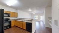 Located at 4647 Wenda St in Houston, TX, this single-story, one-bedroom, one-bathroom home offers a functional and comfortable layout. The combined kitchen and living area forms the heart of the home, featuring rich wood-look flooring that flows throughout the main spaces. The kitchen is well-equipped with warm honey-toned cabinetry, dark granite-style countertops, black appliances including a range and over-the-range microwave, and a peninsula that provides additional counter space and separates the kitchen from the living area. The living room is bright and airy, with a ceiling fan overhead, a large window, and a glass-panel exterior door that floods the space with natural light and offers views of the outdoors. Built-in shelving along one wall adds practical storage. The bedroom is a generously sized retreat finished with plush carpet, a ceiling fan, and a window with outdoor views. The full bathroom features wood-look flooring, a shower-tub combination, a vanity with warm wood cabinetry, and access to a dedicated closet. Neutral wall tones throughout create a clean, versatile canvas for any décor style.
