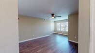 Located at 301 N Gross Rd in Kingsland, Georgia, this single-floor, two-bedroom, two-bathroom home offers a well-organized and functional layout. The open-concept living, dining, and kitchen area serves as the heart of the home, featuring dark hardwood-style flooring, neutral beige walls, a textured ceiling, and a ceiling fan with light. A large window allows natural light to fill the living space, creating a bright and welcoming atmosphere.

The kitchen is equipped with warm oak cabinetry, white countertops, a white electric range, and a full-size refrigerator, providing ample storage and prep space. Both bedrooms are carpeted for comfort and include ceiling fans. The primary bedroom is a generous size with access to a closet and natural light from a window. The second bedroom also offers good proportions with its own closet access.

The two bathrooms are clean and functional, each featuring a tub-shower combination. A dedicated laundry room includes washer and dryer hookups — both water and electric — along with overhead wire shelving. Four closets throughout the home provide excellent storage capacity. A utility room and hallway complete the practical and efficient floor plan of this Kingsland residence.