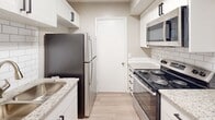 Located at 1000 Woodbrook Pl NE in Concord, North Carolina, this single-floor unit offers a thoughtfully designed layout with a clean, neutral palette throughout. The spacious living area features light wood-style flooring, a ceiling fan, and large windows that invite an abundance of natural light, creating a bright and airy atmosphere. A sliding glass door provides access to an outdoor area, further enhancing the sense of openness.

The galley-style kitchen is well-appointed with white cabinetry accented by modern hardware, granite countertops, a classic subway tile backsplash, and a full suite of stainless steel appliances including a refrigerator, range, and over-the-range microwave. Light wood-style flooring continues seamlessly through this space.

The bedrooms are generously proportioned, each finished with soft wall-to-wall carpeting, ceiling fans with integrated lighting, and windows that allow for natural light and outdoor views. At least one bedroom features a spacious closet with built-in shelving. The bathrooms are clean and functional, each offering a tub-shower combination, a white vanity with integrated sink, and well-lit mirrors. Neutral tones and textured ceilings are consistent throughout, lending the unit a cohesive and comfortable character.