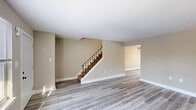 Located at 1026 North Blvd in Bethlehem, PA, this three-floor home offers a well-organized layout across its three levels, including a basement. The main level welcomes you with a bright, open living area featuring light gray hardwood-style flooring, warm neutral-toned walls, and natural light streaming through front-facing windows. A stylish staircase with wrought iron railings serves as a central architectural element connecting all floors. The second living area provides additional flexible space, also finished with the same wood-style flooring for a cohesive look. The kitchen is well-appointed with rich wooden cabinetry, stainless steel appliances including a gas range, microwave, and refrigerator, complemented by light stone-style countertops and tile flooring. Upstairs, the three bedrooms are carpeted for comfort, including a generously sized primary bedroom with multiple closets and ample room to furnish. The two bathrooms are cleanly finished with white vanities and modern light fixtures. The unfinished basement offers additional utility and storage space with concrete walls and flooring. Throughout the home, clean white trim and neutral tones create a cohesive, move-in-ready atmosphere.