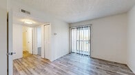 Located at 8131 E Harry St in Wichita, Kansas, this single-floor, two-bedroom, one-bathroom unit offers a practical and well-organized layout. The entryway opens directly into the living room, which features wood-look laminate flooring, a ceiling fan with light, and a sliding glass door fitted with vertical blinds that allows natural light to pour in while providing access to the outdoors. The galley-style kitchen is efficiently designed with white cabinetry lining both sides, light laminate flooring, a double-basin sink, and white appliances including an electric range and refrigerator, offering ample counter and storage space for everyday cooking. Both bedrooms are carpeted and feature textured ceilings, white walls, and windows with horizontal blinds that let in natural light. Each bedroom includes its own closet — one with a sliding-door closet and another with a bi-fold door closet — providing convenient storage. A connecting hallway links the bedrooms and the shared full bathroom, which includes a full-size soaking tub and shower combination with chrome fixtures. The clean, neutral palette throughout the unit creates a bright and cohesive atmosphere, making the space feel open and move-in ready.