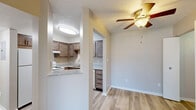 Located at 840 Harvest Dr in Kokomo, Indiana, this one-bedroom, one-bathroom residence offers a thoughtfully organized single-floor layout designed for comfortable everyday living. The entrance welcomes you into a light-filled living area featuring light-toned hardwood-style flooring, neutral warm walls, and a sliding glass door that fills the space with natural light and provides views of the surrounding greenery. A ceiling fan with integrated lighting adds both comfort and function to the living area. The kitchen is efficiently designed with dark wood cabinetry, granite-style countertops, and a range, and flows seamlessly into the dining area, making the space ideal for both cooking and entertaining. The bedroom is a comfortable retreat, featuring plush carpeting, a window with natural light, and generous closet access. The bathroom is well-appointed with a wide granite-top vanity, dark wood cabinetry, a large mirror, and a tiled shower/tub combination with light hardwood-style flooring. Additional highlights include a dedicated laundry area, a utility room, and multiple closets throughout for ample storage. The overall aesthetic is clean, modern, and move-in ready.