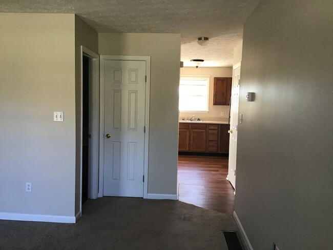 View from living/tv room looking back towards kitchen and coat closet - 214 Shamrock Ln