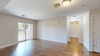 Located at 333 River Dr in Allentown, PA, this single-floor unit offers a thoughtfully designed layout that makes efficient use of its space. Rich hardwood flooring flows throughout, lending warmth and continuity to every room.

The open living room is bright and inviting, with a sliding glass door that leads to a private balcony overlooking a landscaped exterior with mature trees and open sky — an ideal spot for relaxing outdoors. Natural light pours into the space, complementing the clean, neutral wall tones.

The kitchen is a standout feature, showcasing deep-toned cabinetry, granite countertops, a stainless steel sink, and black appliances including a dishwasher and range. An adjacent pantry provides generous storage. The kitchen opens conveniently toward the living area, supporting an easy flow for everyday living.

The bedroom is a comfortable, well-proportioned retreat with hardwood floors, a large window that brings in natural light, and a dedicated closet for storage. A hallway connects the main spaces, and the bathroom includes a full tub and shower surround.

The entrance provides a welcoming transition into the home. With a practical layout, quality finishes, and a private outdoor space, this unit offers a refined and functional living environment in Allentown, PA.