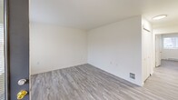 Located at 1590 NE Northwood Dr in Pullman, WA, this single-floor, 3-bedroom, 2-bathroom unit offers a clean, modern aesthetic throughout. Light-toned luxury vinyl plank flooring runs seamlessly across the entire unit, complementing the bright white walls and creating a cohesive, contemporary feel.

The open-concept layout brings together the living room, dining area, and kitchen into one shared space, maximizing functionality. The kitchen features white cabinetry, a full-size refrigerator, and an electric range, all illuminated by overhead fluorescent lighting. A hallway connects the main living area to the private bedroom wing.

Each of the three bedrooms is well-proportioned and filled with natural light from windows with blinds. The primary bedroom includes a sliding-door closet, offering convenient storage. The additional bedrooms also feature sliding closets and baseboard heating units. In total, four closets are distributed throughout the unit.

The two bathrooms are cleanly finished, each equipped with a tub-shower combination, a single-sink vanity with a mirror, and LVP flooring. An in-unit laundry area adds everyday convenience. A private patio extends the living space outdoors. The overall ambiance is bright, clean, and move-in ready, suited for comfortable everyday living.