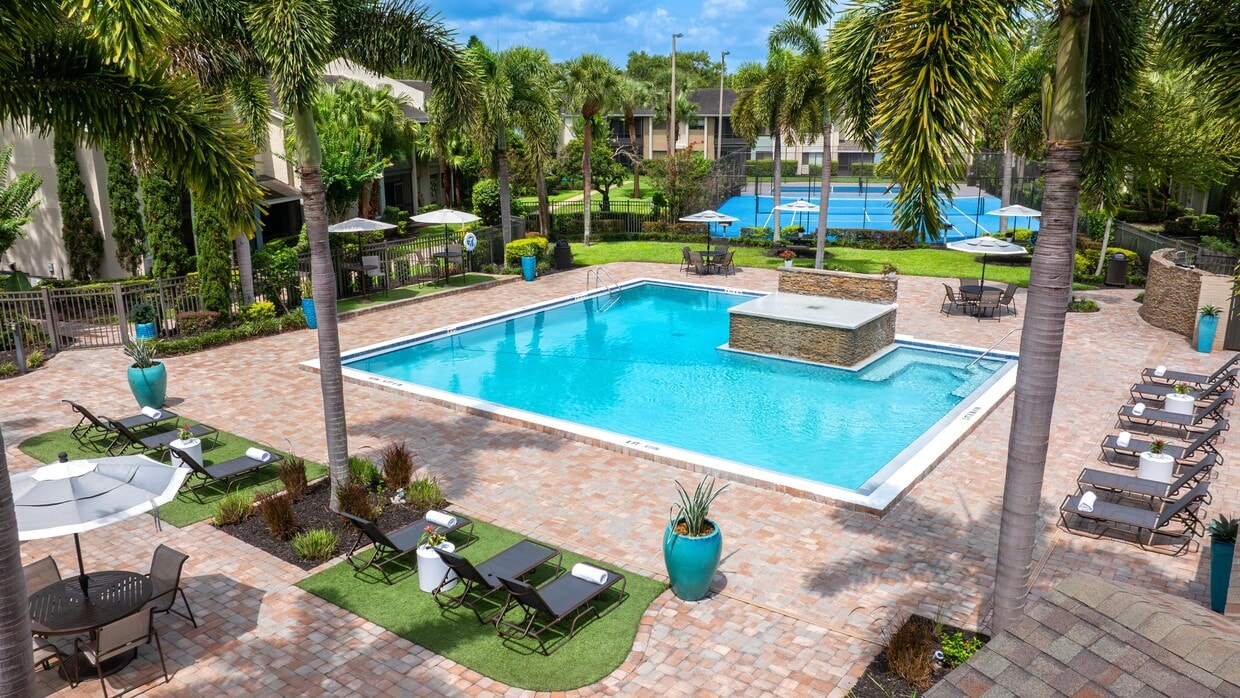 Cool off in style at Harper Grand, where our expansive pool area features a stunning water feature, shaded outdoor dining, and plush loungers. - Harper Grand