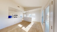 Located at 9201 Riverside Pkwy in Tulsa, OK, this two-story home offers 3 bedrooms and 2 bathrooms across a thoughtfully designed layout. The main living level is bright and open, showcasing soaring vaulted ceilings that amplify the sense of space. Large windows flood the carpeted living area with natural light, while a sliding glass door leads to an outdoor balcony with exterior views. The kitchen is galley-style with hardwood-look flooring, white cabinetry, light granite-style countertops, and stainless steel appliances including a refrigerator, range, microwave, and dishwasher. A dedicated pantry closet adds convenient storage. The two full bathrooms are clean and functional, with one featuring a tiled shower-tub combo, white vanity, and tile flooring. The generously sized primary bedroom impresses with dramatically high vaulted ceilings, a ceiling fan, plush carpet, and access to both a walk-in closet and an en-suite bathroom. Additional bedrooms are bright and well-proportioned, one featuring an arched window that enhances its architectural character. The attached garage on the lower level includes an automatic opener, providing secure and convenient parking.