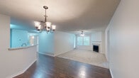 Located in Baton Rouge, Louisiana, this single-story, 2-bedroom, 2-bathroom home offers a well-designed layout with a comfortable mix of hard and soft flooring surfaces. A welcoming hallway with rich, dark wood-style flooring leads into the open-concept living and dining area. The dining space features an elegant chandelier, while the adjoining living room is highlighted by a tile-surround fireplace with a classic white mantel and a ceiling fan, creating a warm and inviting atmosphere. A window allows natural light to fill the space. The kitchen is equipped with white cabinetry, light countertops, black appliances including a range, microwave, and refrigerator, and opens to the main living area via a breakfast bar peninsula. The spacious primary bedroom includes plush carpeting, a ceiling fan, and a generous walk-in closet with built-in shelving. The second bedroom also features carpeting and a ceiling fan. Both bathrooms are functional and clean, with one offering a full tub-shower combination. A dedicated laundry room with wood-style flooring, built-in shelving, and washer/dryer hookups adds everyday convenience. Textured ceilings and neutral tones throughout create a cohesive and move-in-ready feel.