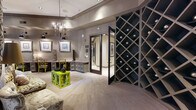 Located in Houston's vibrant Montrose neighborhood, this single-floor amenity center at 4310 Dunlavy St offers a refined and well-appointed experience across a generously sized layout. The space is divided into distinct functional areas, each thoughtfully designed with upscale finishes and cohesive décor.

The expansive fitness center is a standout feature, offering an extensive selection of strength-training machines, free weights, benches, treadmills, ellipticals, stationary bikes, and a spin cycle. Patterned carpet flooring, large framed wall art, floor-to-ceiling mirrors, and bold gold pendant lighting lend the gym a polished, boutique aesthetic. Natural light streams in through large windows, and a ceiling fan adds comfort during workouts.

Adjacent to the gym, a welcoming hallway connects to a sophisticated lounge area furnished with a floral sofa, vibrant accent tables, built-in workstations, and a crystal chandelier overhead — ideal for remote work or casual gatherings. Framed artwork lines the walls, adding a gallery-like ambiance.

A private conference room features a long wooden table, upholstered dining chairs, a crystal chandelier, decorative mirrors, and a large display screen, making it well-suited for meetings or private events. A dramatic diamond-pattern wine storage wall lines the connecting corridor, adding a luxurious architectural focal point throughout the transition spaces.