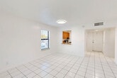 Located in Davie, FL, this single-floor, one-bedroom, one-bathroom unit offers a clean and functional layout ideal for comfortable living. The combined living and dining area is bright and open, featuring white tile flooring and natural light from windows with blinds that offer views of the surrounding outdoor greenery. A pass-through window connects this main living space to the kitchen, which is equipped with warm wood-toned cabinetry, a stainless steel refrigerator, and a range. The white walls and tile flooring throughout the common areas give the unit a fresh, airy feel. The bedroom is a comfortable, well-proportioned space finished with soft carpeting and a window that brings in natural light. A louvered closet door provides convenient storage within the room. Four closets throughout the unit offer generous overall storage. The bathroom features a full tub-shower combination with white tile surround and chrome fixtures. A hallway connects the living areas to the private spaces, creating a straightforward and practical floor plan. The unit's consistent neutral palette and tile flooring make it easy to personalize and maintain.