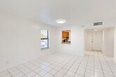 Located in Davie, FL, this single-floor, one-bedroom, one-bathroom unit offers a clean and functional layout ideal for comfortable living. The combined living and dining area is bright and open, featuring white tile flooring and natural light from windows with blinds that offer views of the surrounding outdoor greenery. A pass-through window connects this main living space to the kitchen, which is equipped with warm wood-toned cabinetry, a stainless steel refrigerator, and a range. The white walls and tile flooring throughout the common areas give the unit a fresh, airy feel. The bedroom is a comfortable, well-proportioned space finished with soft carpeting and a window that brings in natural light. A louvered closet door provides convenient storage within the room. Four closets throughout the unit offer generous overall storage. The bathroom features a full tub-shower combination with white tile surround and chrome fixtures. A hallway connects the living areas to the private spaces, creating a straightforward and practical floor plan. The unit's consistent neutral palette and tile flooring make it easy to personalize and maintain.